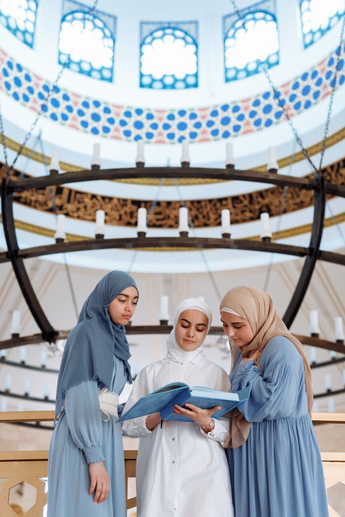Three women in a mosque read a holy book during Ramadan. Peaceful and spiritual scene.